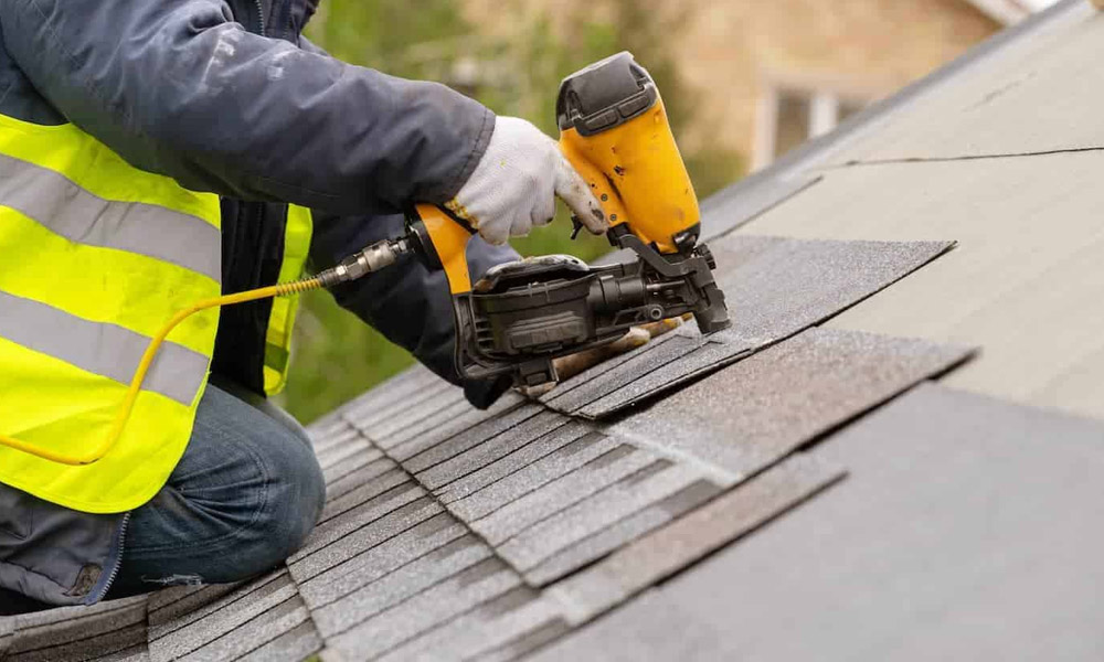 A worker installing a new shingles roof in Charleston, SC